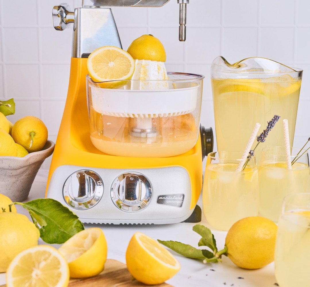 Ankarsrum med citruspressen fäst på en bänk. Karaffer fyllda med nygjord lemonad.