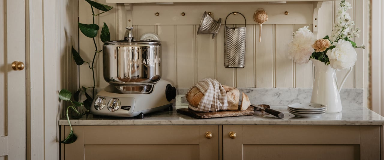 A kitchen with a counter and shelves filled with pots and pans.