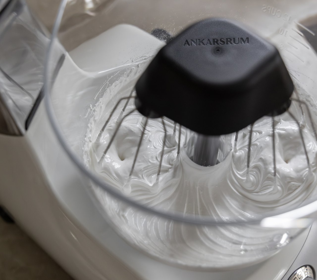 A close up of an ankarsrum assistent, with balloon whisks.