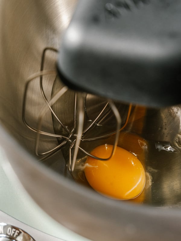 Two eggs in a metal bowl on a counter.