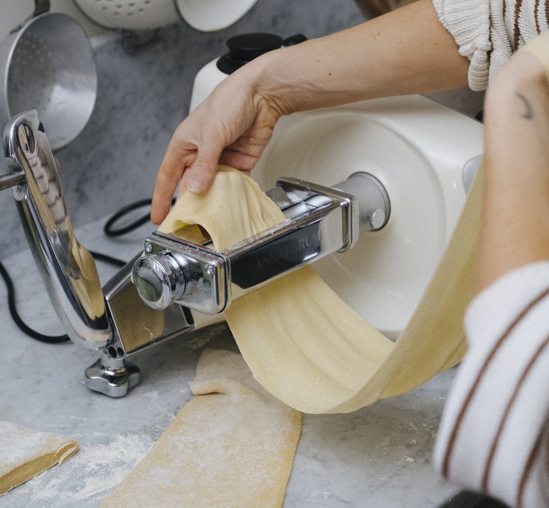 En person som gör färsk pasta med en pastatillbehör.