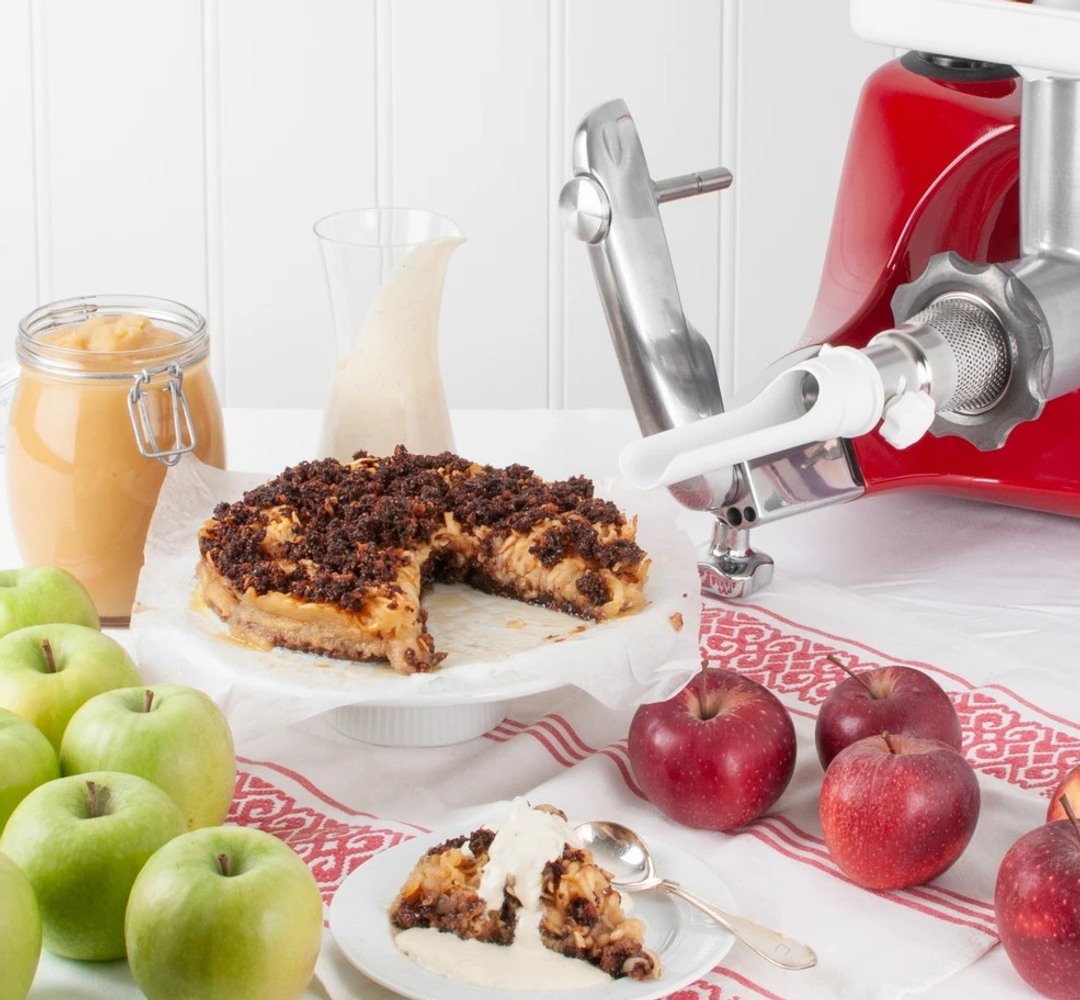 A table topped with a plate of apple cake and apples.