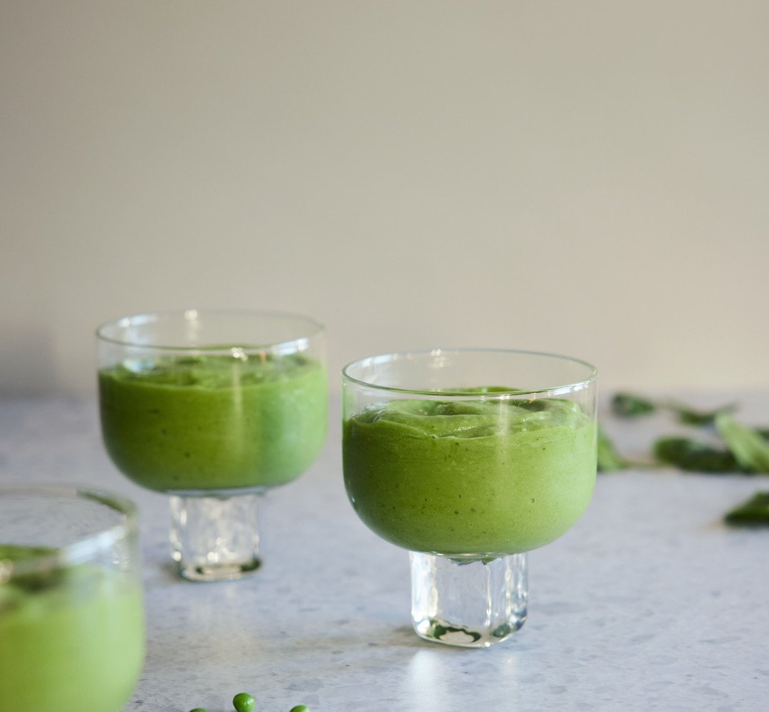 Grön smoothie i tre glas på ett ljust köksbord.