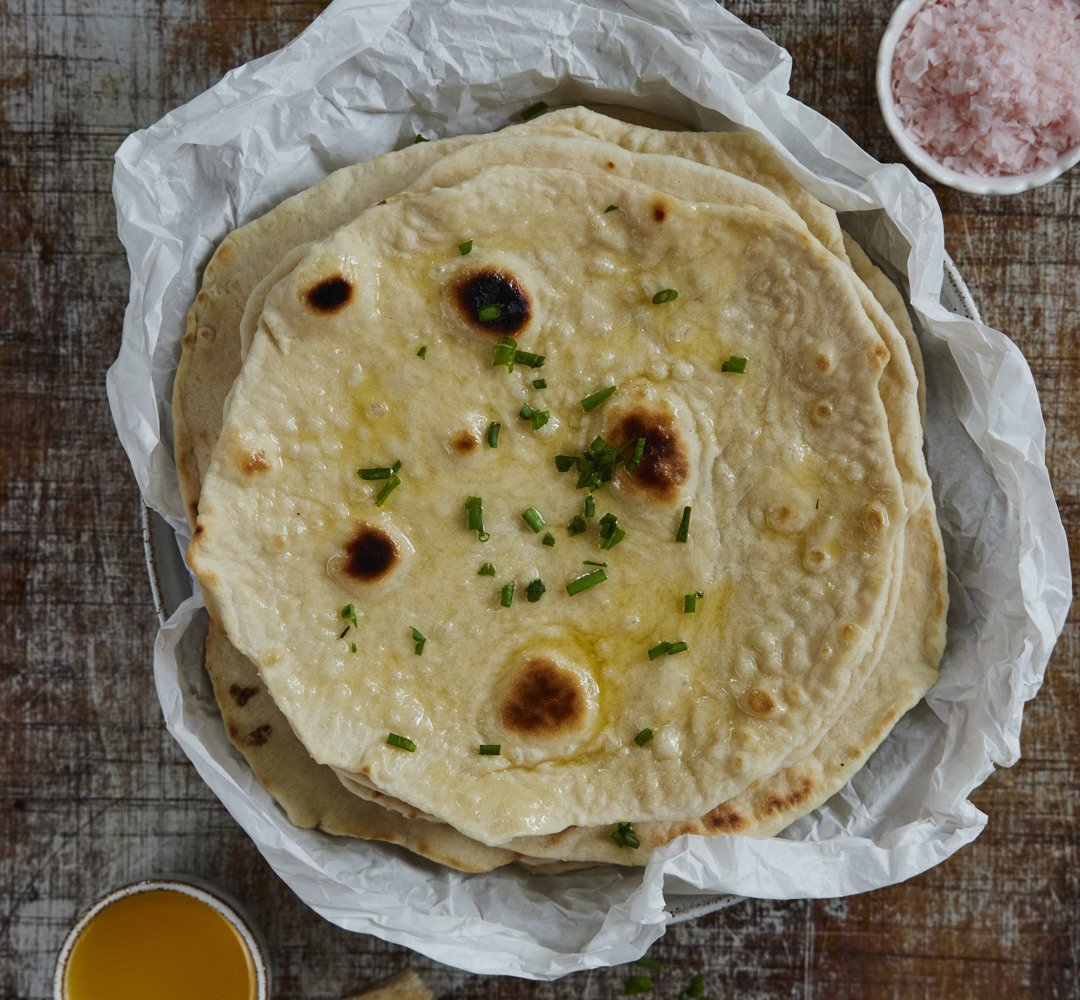 A table topped with a plate of tortillas
