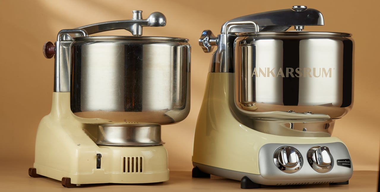 En gammal Ankarsrum Assistent från 1940-talet och en av de nyare modellerna från 2000-talet, båda i färgen Creme light.