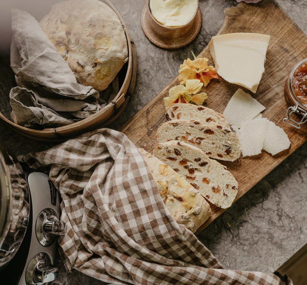 A wooden cutting board topped with lots of bread.