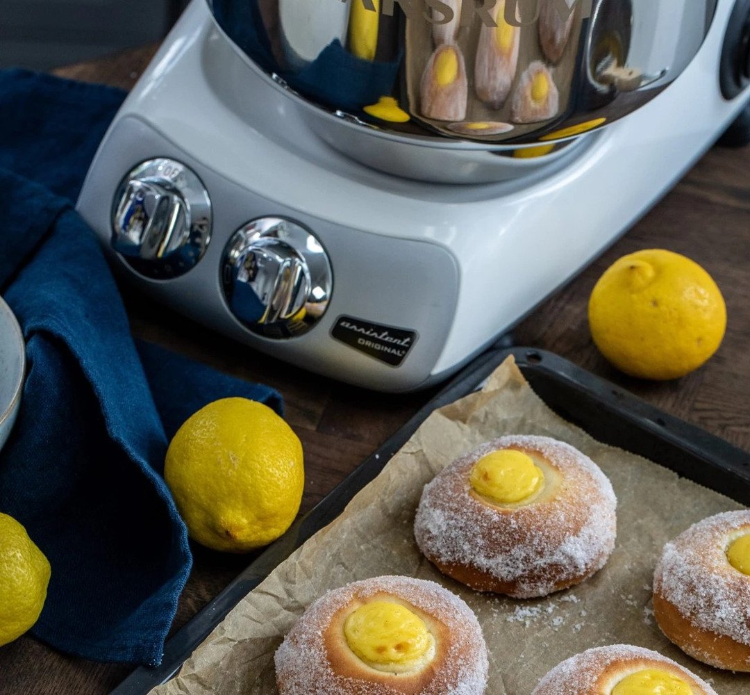 Sun buns on a baking tray with the Ankarsrum Assistent Original in the background.