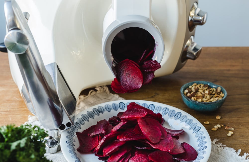 A plate of Beetroot carpaccio
on a table next to a blender.
