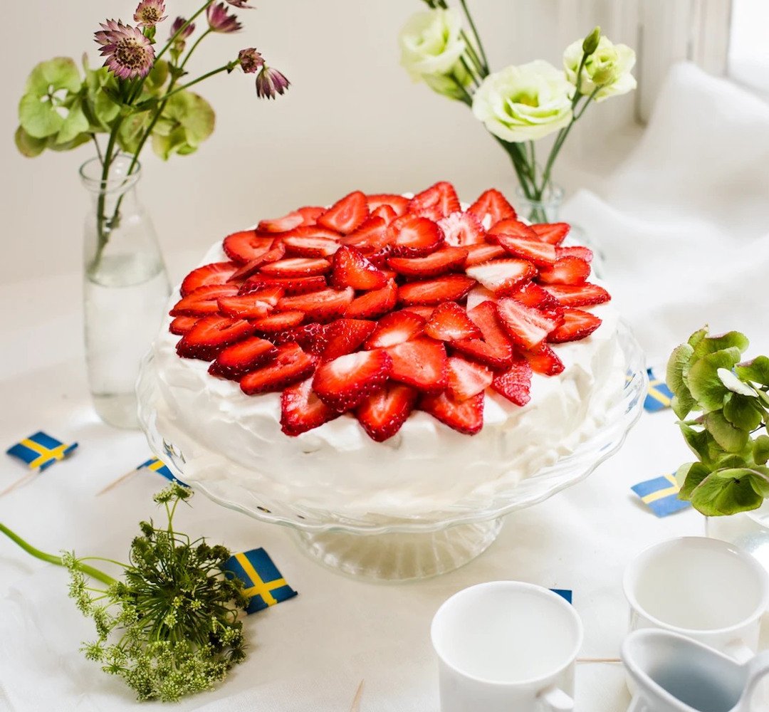 A cake with strawberries on top of it on a table.