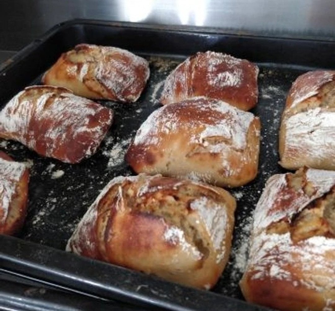 En plåt med nybakade surdegs frallor med honung. 