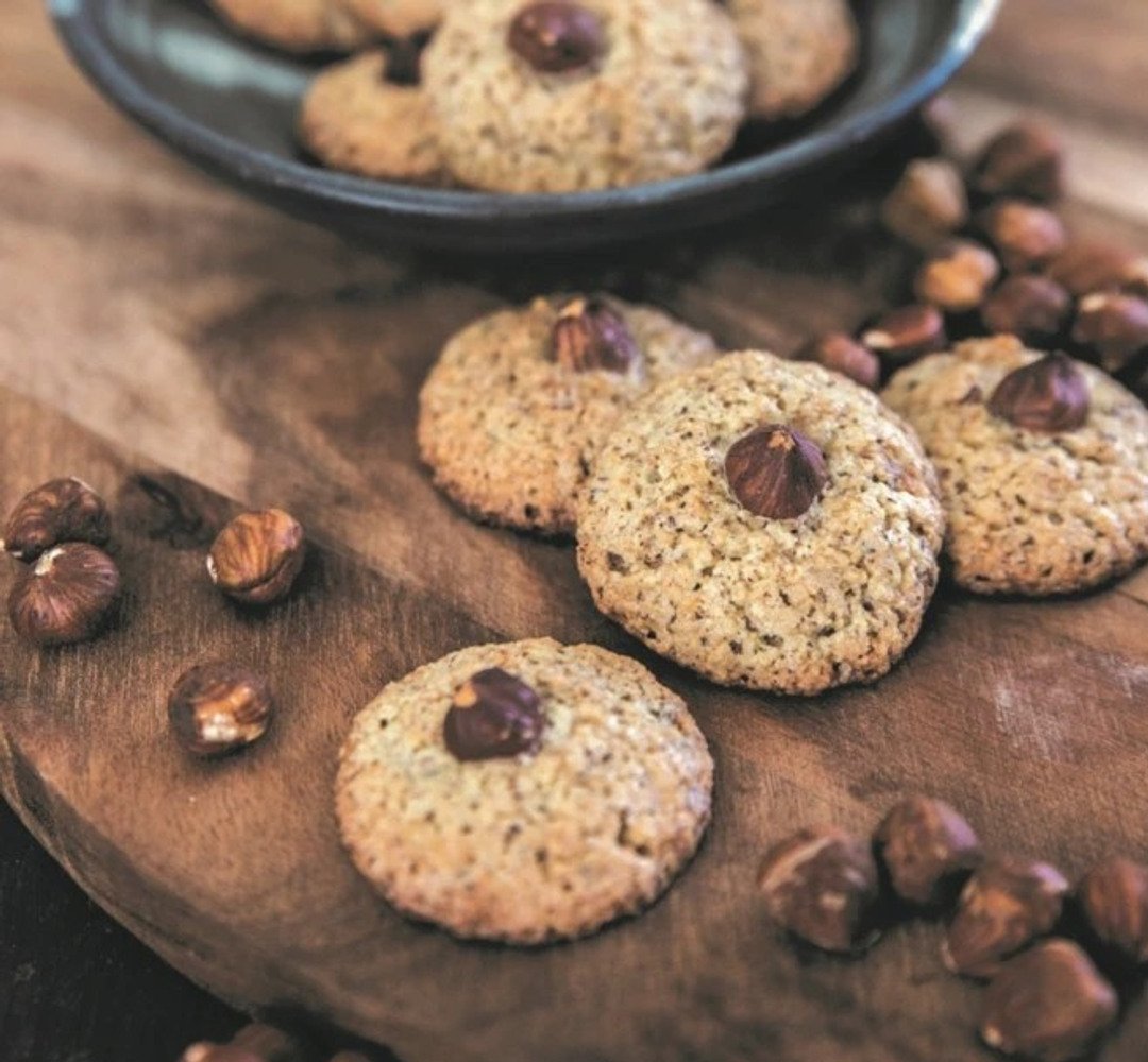 A wooden table topped with cookies and nuts.