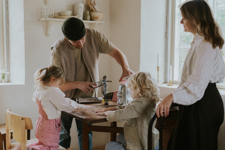 A group of people standing around a wooden table.
