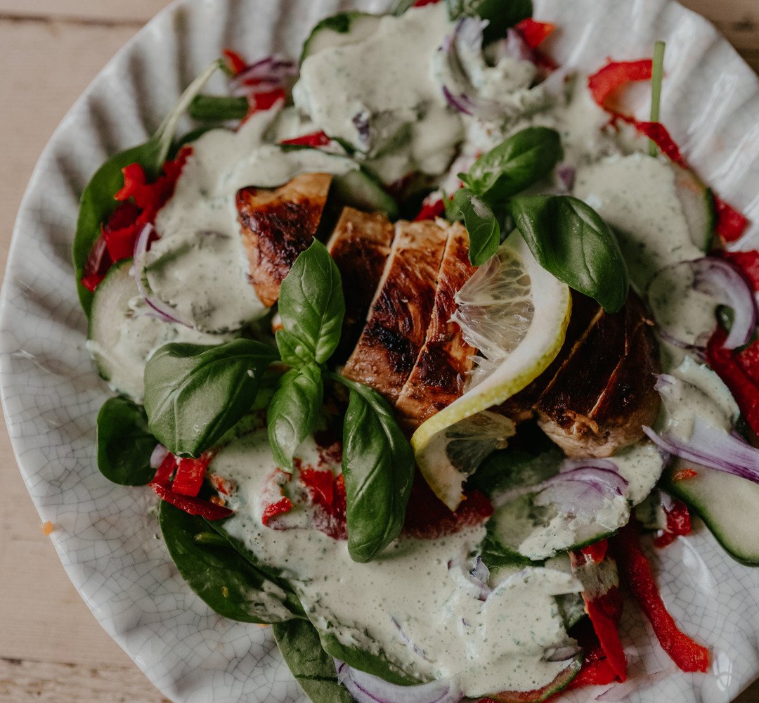 En tallrik med kycklingsallad på ett träbord.