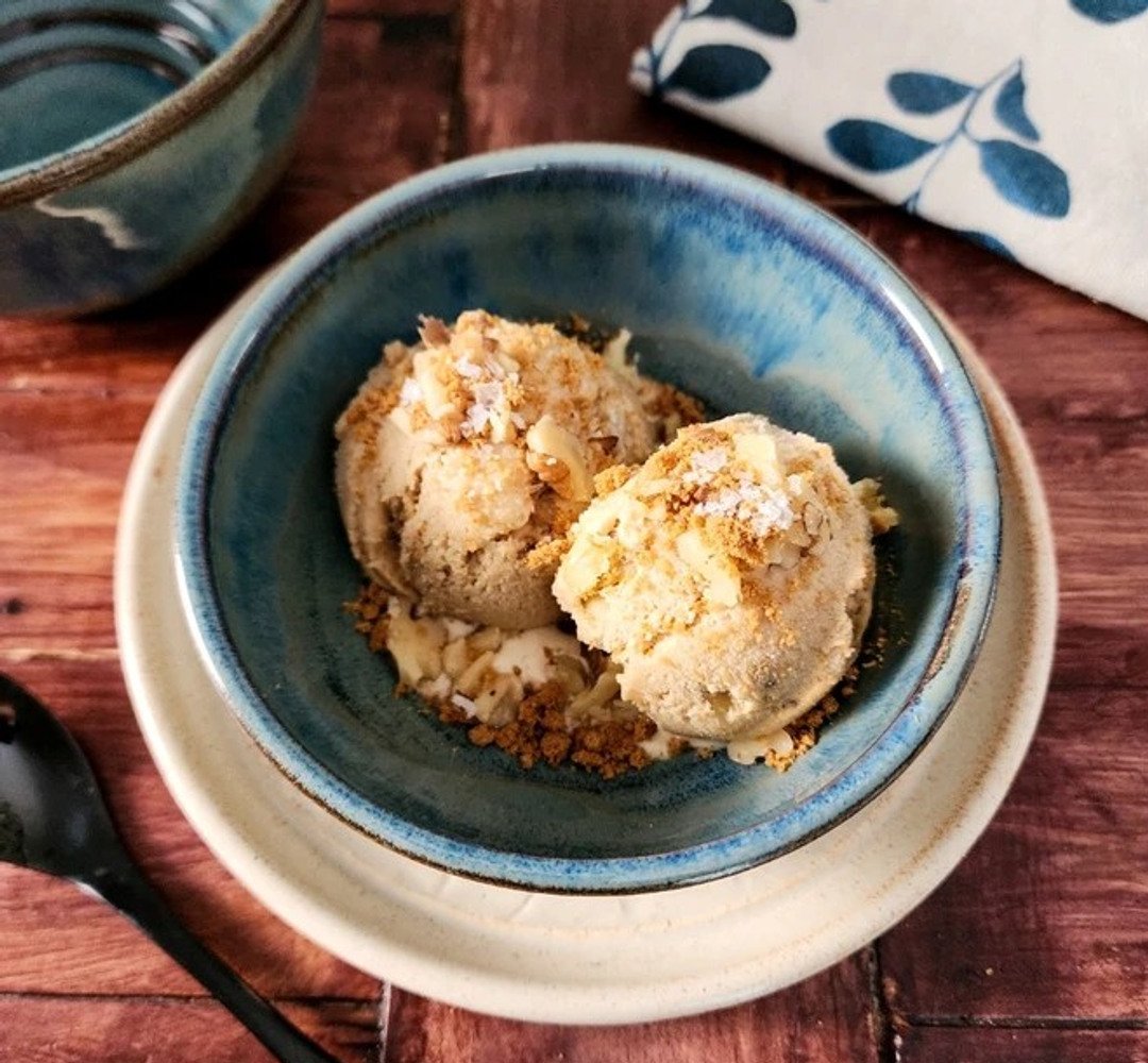 A bowl of ice cream on a wooden table.