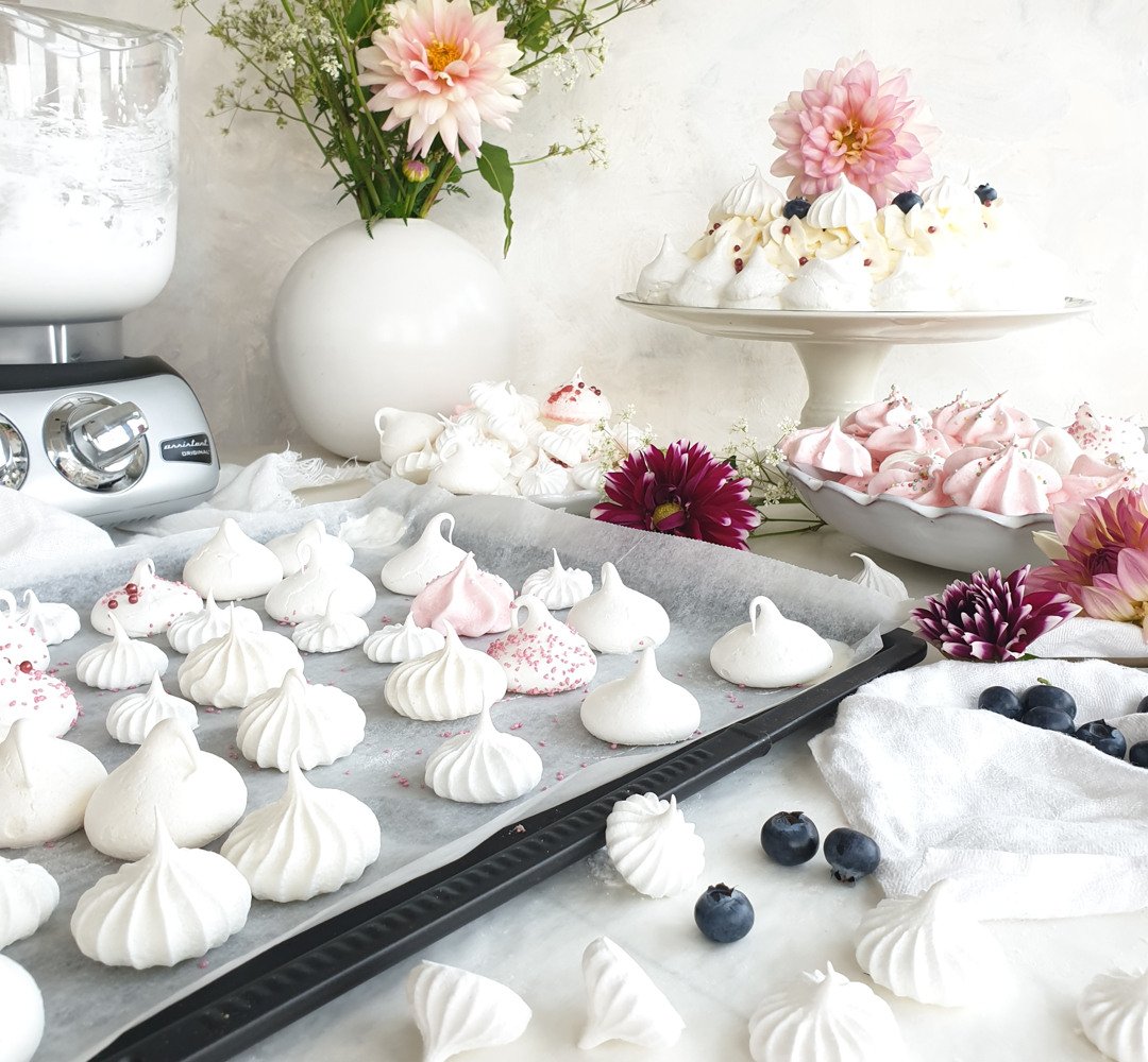 A baking tray filled with meringues.