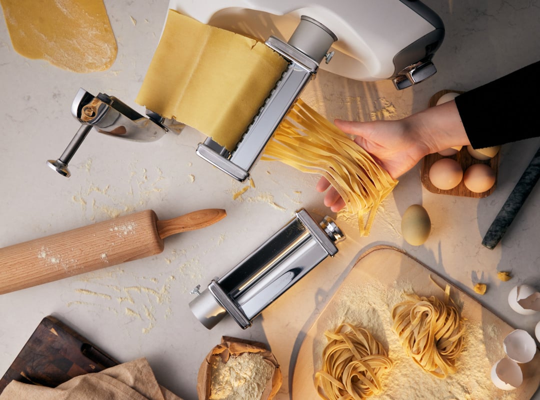 A person is making pasta on a table.