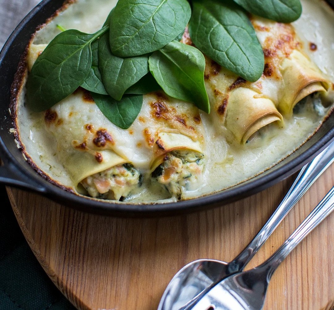 A skillet filled with pasta cannelloni and spinach.