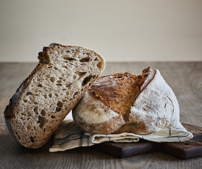 A loaf of Rye sourdough bread sitting on top of a wooden table.