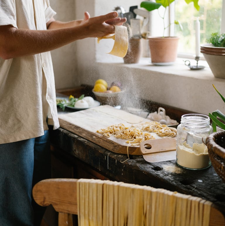 A man is sprinkling pasta on a table.