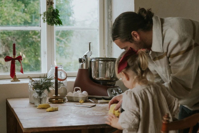 Kjøkkenmaskin med deigrulle som elter en saftig deig til julekake med rosiner og sukat, en ekte norsk juletradisjon.